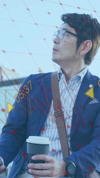 Animation of financial data processing over asian businessman using smartphone on city street
