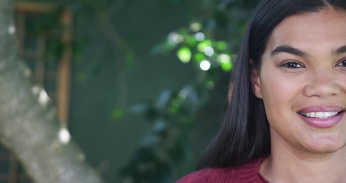African American woman reacting to framing shift smiling in garden by trellis red sweater