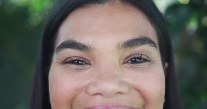 Adult African American woman opening eyes, smiling with sun lifting eyelids in garden