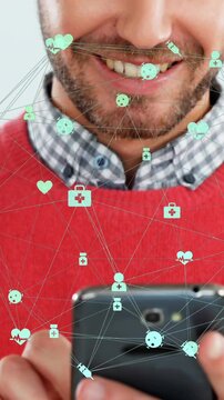 Animation of network of connections with icons over caucasian man using smartphone