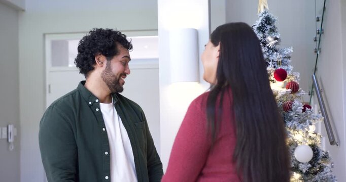 African American couple making eye contact and sharing warm holiday greeting beside Christmas tree