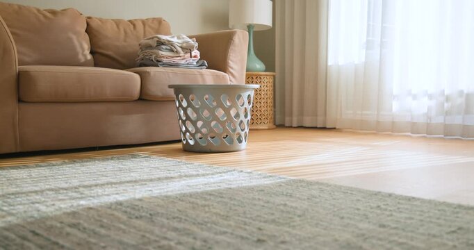 Camera is panning, centering plastic basket, sunlight revealing folded linen conveying tidy room