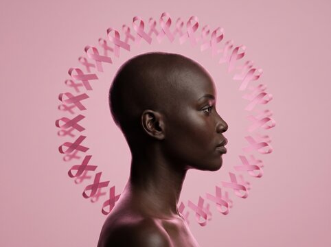 Side profile of a beautiful bald Black woman framed by floating pink ribbons on a pink background. A powerful breast cancer awareness and outubro rosa campaign concept for health and hope.