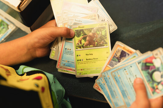 Chicago, IL/USA - August 27, 2026: Child sorting through a stack of Pokemon trading cards