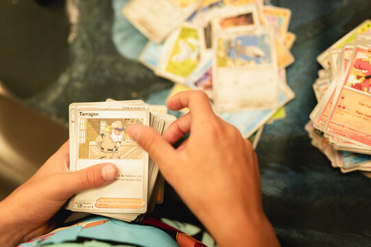 Chicago, IL/USA - August 27, 2026: Child sorting Pokemon trading cards into organized piles at home