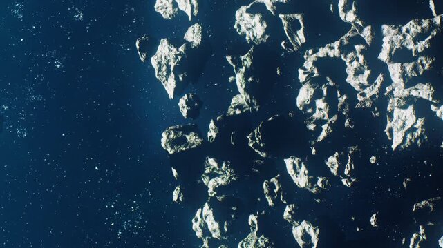 A group of asteroids is seen drifting in outer space. The scene shows a dark background filled with distant stars. The asteroids are various shapes and sizes, creating a unique view.