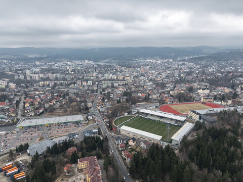Jablonec nad Nisou, Czech Republic - March 23, 2025: Aerial view of Stadion Strelnice, home of FK Jablonec, with the city and surrounding hills beyond.