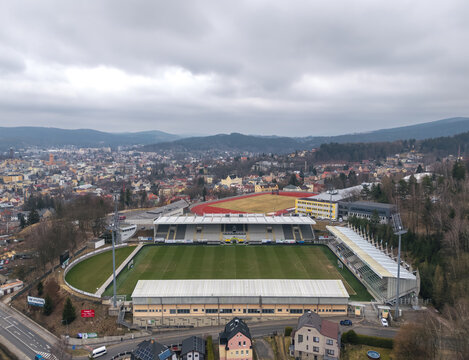 Jablonec nad Nisou, Czech Republic - March 23, 2025: Aerial view of Stadion Strelnice, home of FK Jablonec, surrounded by residential areas and wooded hills.