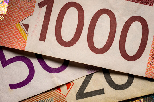 Macro close-up of overlapping Serbian dinar banknotes in different denominations, showing large printed values and detailed currency patterns.