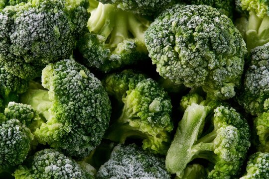 Frozen broccoli pieces on a flat surface in a close-up view showing details of the texture