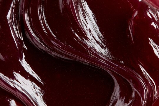Bright red berry sauce swirled on a surface in a kitchen setting