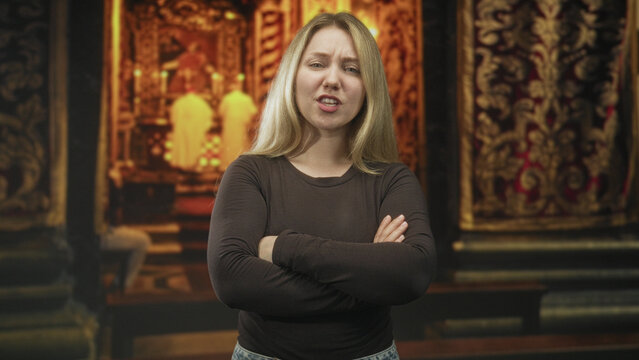 Blonde woman with folded arms and a grimace, standing before an ornate altar with robed priests in a church interior; disgust defiance.