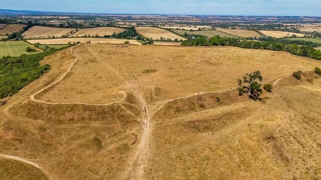 An aerial view flying above the entrance and remains of the Iron Age Hillfort in rural Leicestershire, UK in late summertime