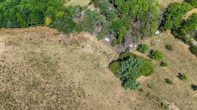 An aerial view scanning up towards the remains of the Iron Age Hillfort in rural Leicestershire, UK in late summertime