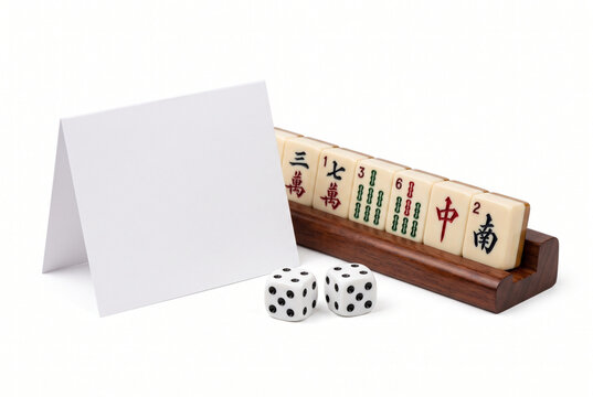 Blank card next to mahjong tiles on a rack and dice