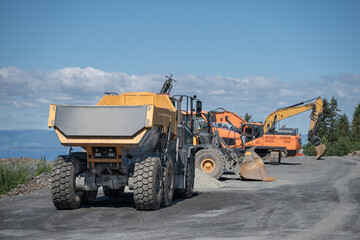 Heavy Construction Machinery and Dump Trucks Parked at Worksite in Malvik Norway © HansMorten