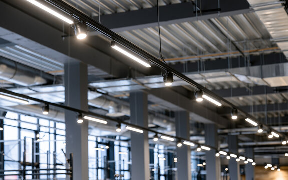 Directional LED lights on rails under the ceiling in a modern warehouse, shopping center building, office or other commercial real estate object.