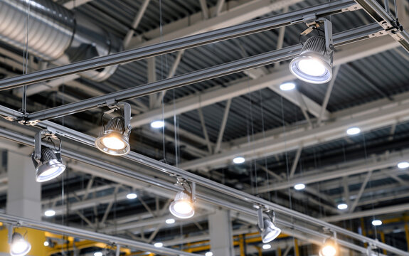 Directional LED lights on rails under the ceiling in a modern warehouse, shopping center building, office or other commercial real estate object.