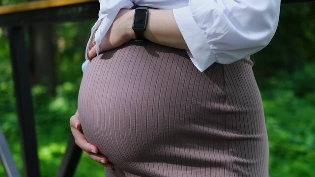 Close-Up of Pregnant Belly Held with Both Hands, Expectant Mother, Maternity Wellness, Body Changes, Motherhood and Baby on the Way