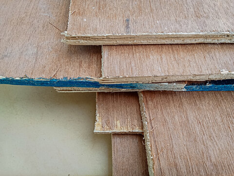High angle view of unevenly stacked plywood sheets with blue painted edges