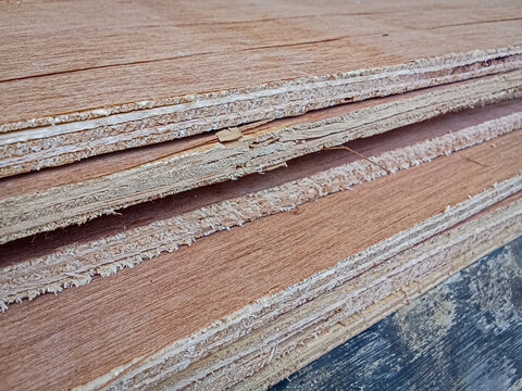 Angle view of stacked rough plywood board edges with visible wood fibers