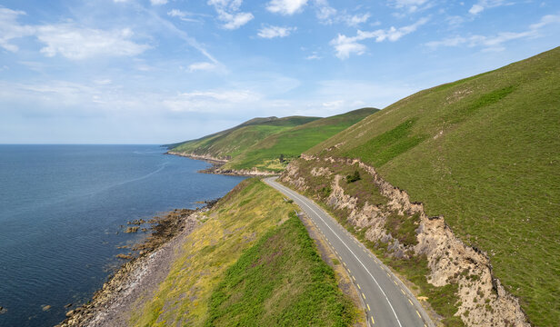 Dingle peninsula coastal road winding along the rocky atlantic ocean coastline, Ireland