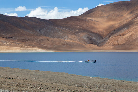 Boat in Pangong Lake surrounded by mountains