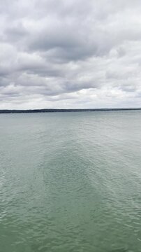 overcast day with layered gray cloud cover reflecting on the rippled lake water surface