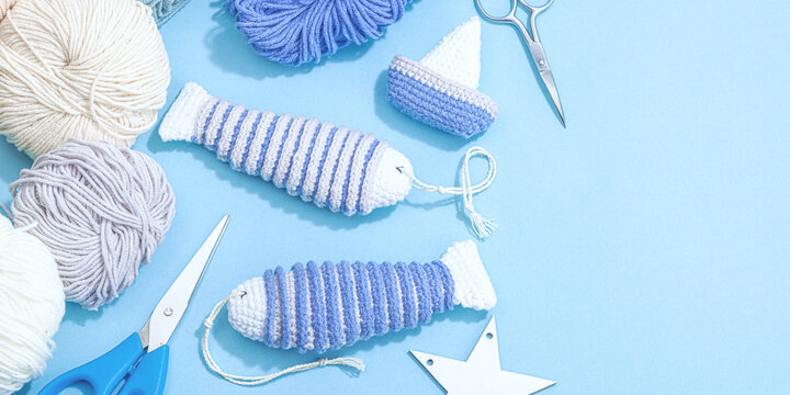 Handmade marine background. Crocheted sardine fishes, boats, nautical style, traditional sea decor
