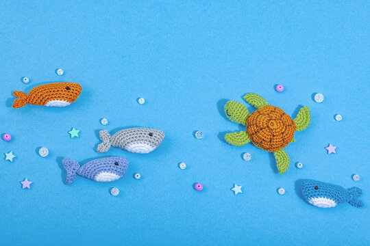 Summer crocheting concept. Handmade sharks and turtle, marine style. Set of different underwater animals