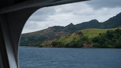 Obraz premium Scenic view passing rugged tropical Ovalau Island on ferry in Fiji, South Pacific