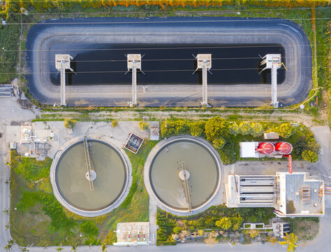 Aerial view of the Wastewater Treatment Institute featuring large circular sedimentation tanks and a rectangular aeration basin surrounded by greenery in Herzliya, Tel Aviv District, Israel.