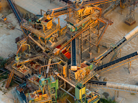 Aerial view of an industrial aggregate processing plant with conveyor belts, metal structures, and machinery in Rome, Lazio, Italy.