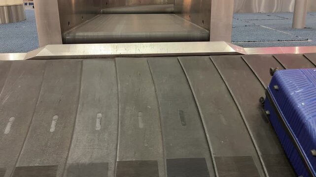 Tracking luggage moving along airport baggage carousel, with suitcases arriving for passengers after flight in modern international terminal, shot handheld. High quality 4k footage