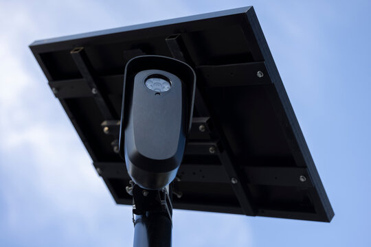 An Artificial Intelligence AI Camera surveils a city street for car license plates.