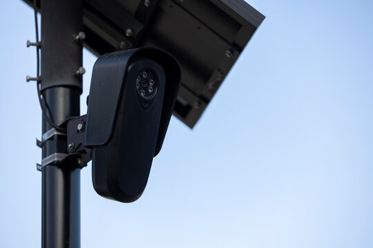 An Artificial Intelligence AI Camera surveils a city street for car license plates.