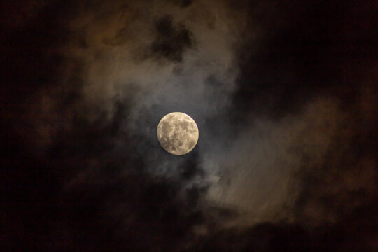 Full moon in the night sky with clouds