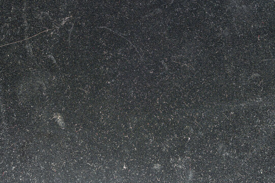 Dark Granular Matte Surface Texture Background with Fine Particulate Matter and Subtle Imperfections Softly Focused for Ample Copy Space