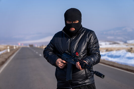 A bandit stands on the road with a machine gun