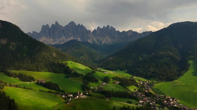 serene mountain landscape with scattered houses and lush green fields in hilly terrain from a wide-angle perspective above, static scene with natural beauty and calm atmosphere.