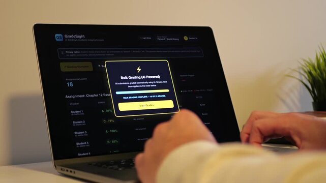 Educator at a laptop using AI software for automated bulk grading of student essays while scanning for unauthorized student AI usage and plagiarism