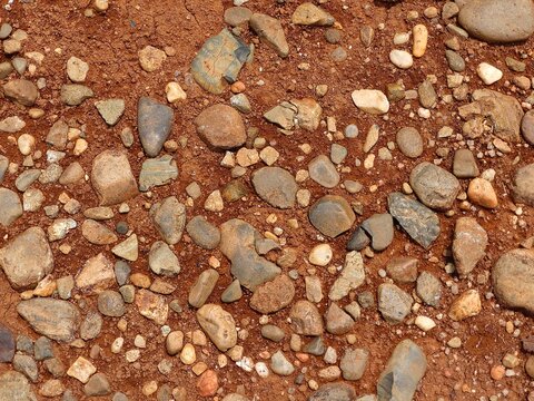 Natural Red Laterite Soil with Mixed Gravel and Stones Texture Background