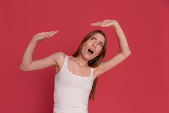 Surprised woman measuring a large imaginary object