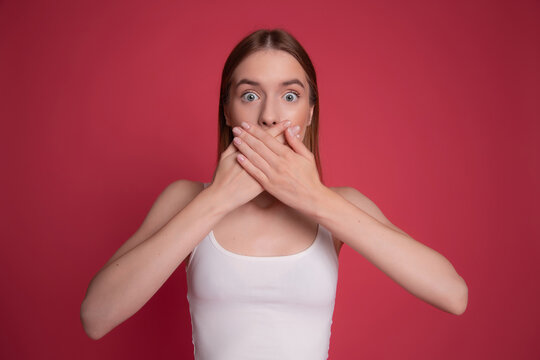 Shocked woman covering her mouth with both hands