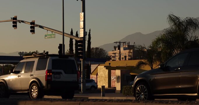 Fontana, California, USA - November 9, 2024: Afternoon traffic passes on Valley Blvd in front of dense apartment housing. 