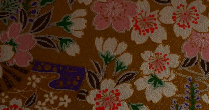Traditional Japanese Floral Pattern with Cherry Blossoms and Colorful Flowers - Traditional Japanese floral pattern featuring cherry blossoms and colorful stylized flowers with leaves on a warm brown 