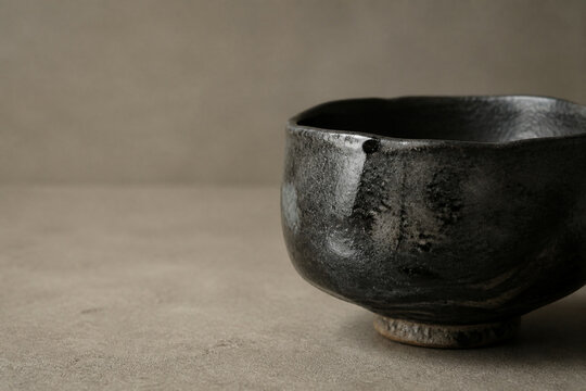 Raku tea bowl, Japanese black pottery still life with copy space