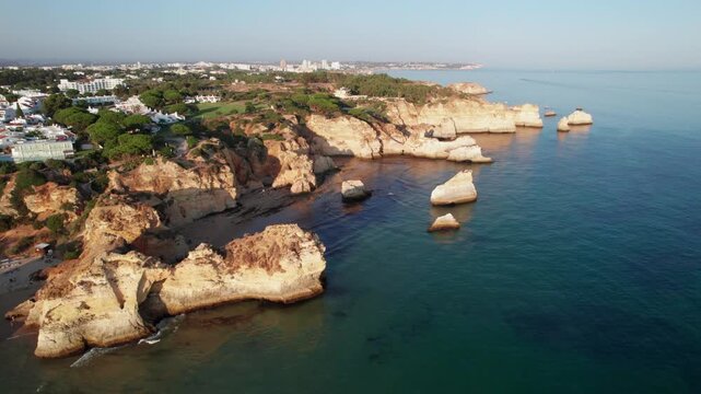 Aerial perspective of the stunning Praia dos Tres Irmaos coastline in the Algarve region of Portugal, featuring its distinctive cliffs