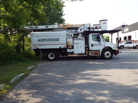Gatineau, Quebec, Canada &ndash; June 30, 2026: A "white Asplundh utility bucket truck" is parked on an asphalt lot near trees and a building exterior on Bd Saint-Ren&eacute; E.
