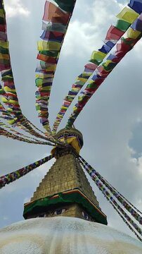 The imposing Boudhanath Stupa in Kathmandu, Nepal. The world's largest Buddhist stupa. The Boudhanath Stupa in Kathmandu, surrounded by colorful Buddhist prayer flags fluttering in the wind.